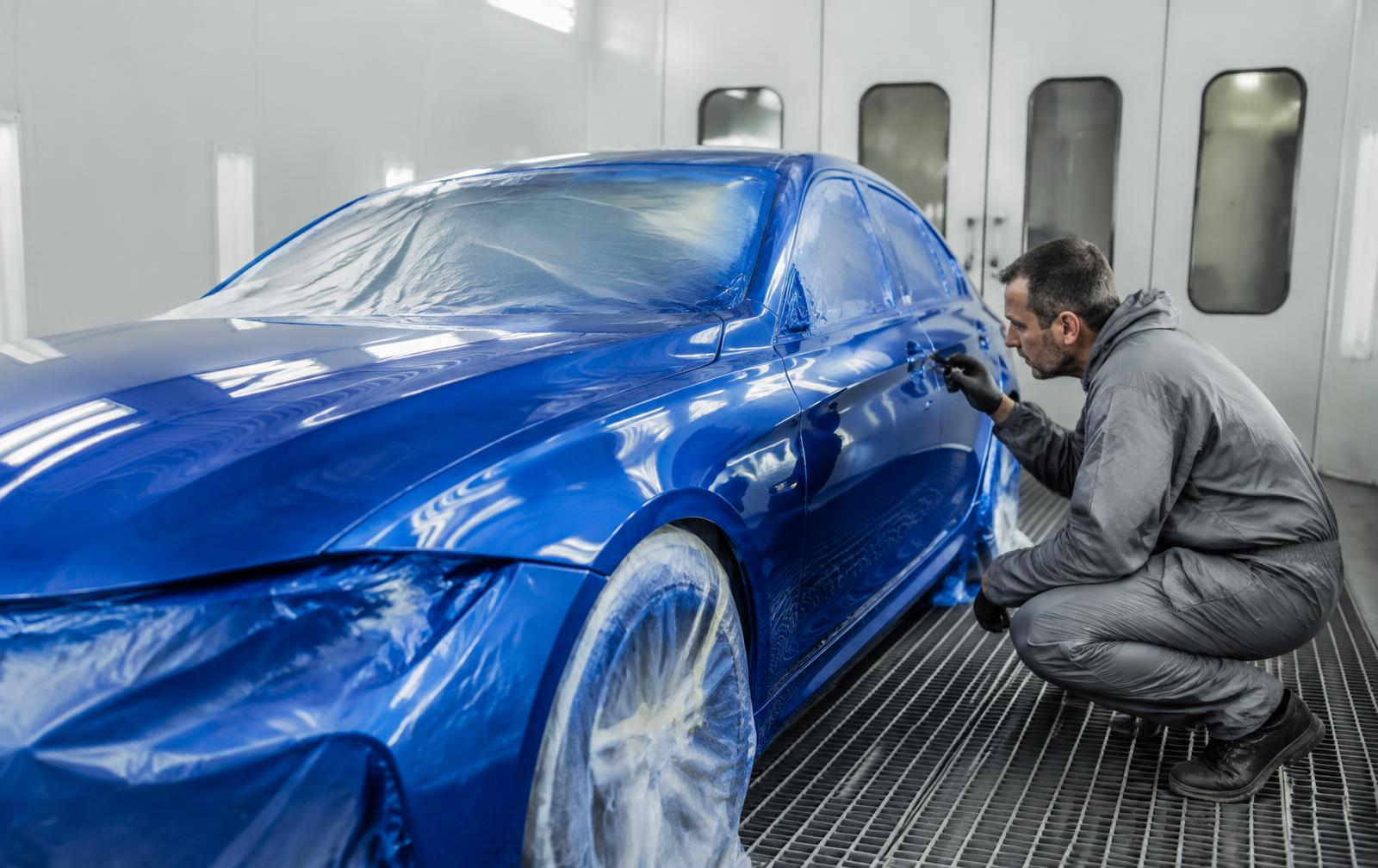 Technician inspecting a freshly painted car